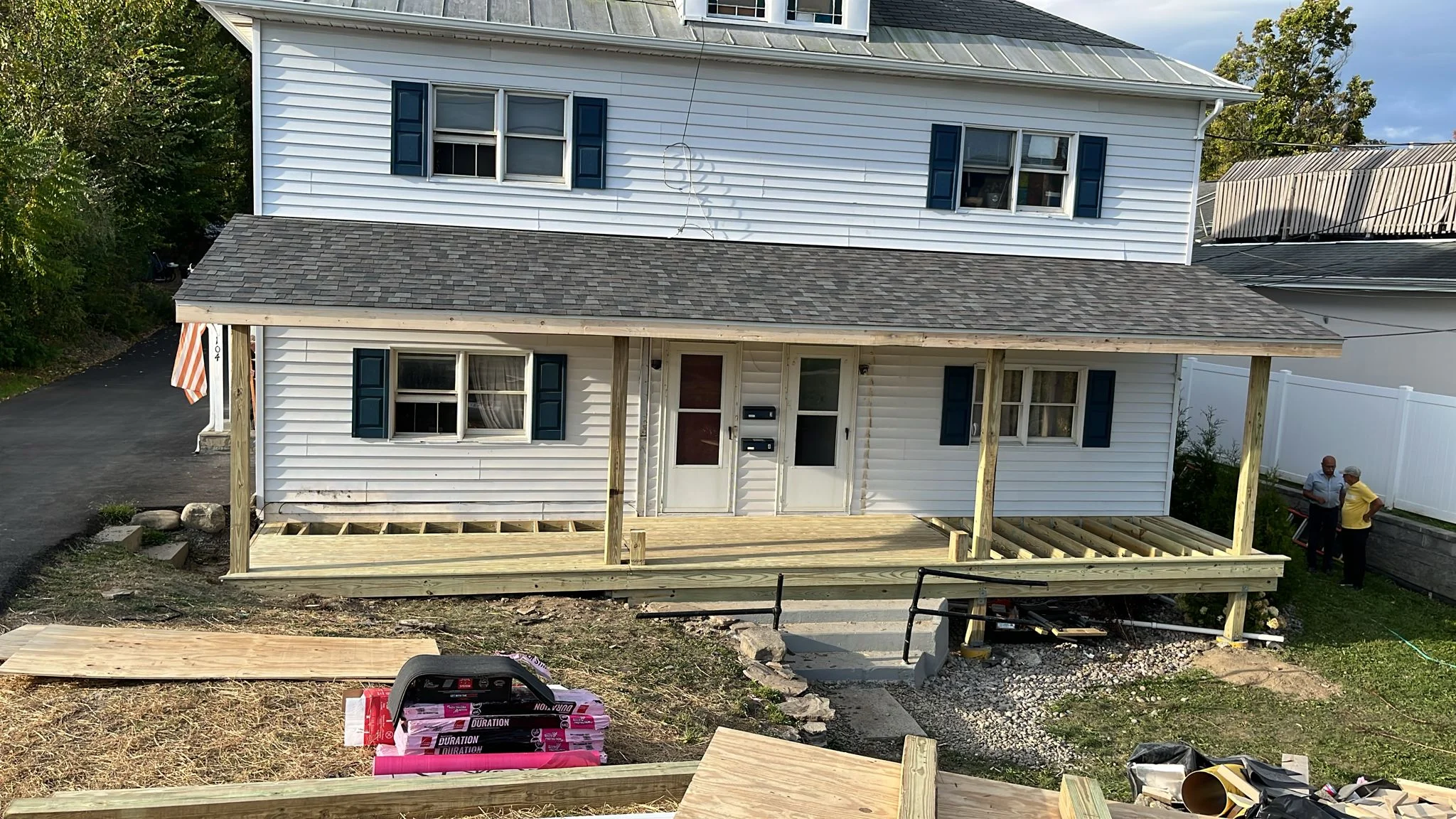 Pressure-treated wood deck framing with posts and joists under construction on residential home