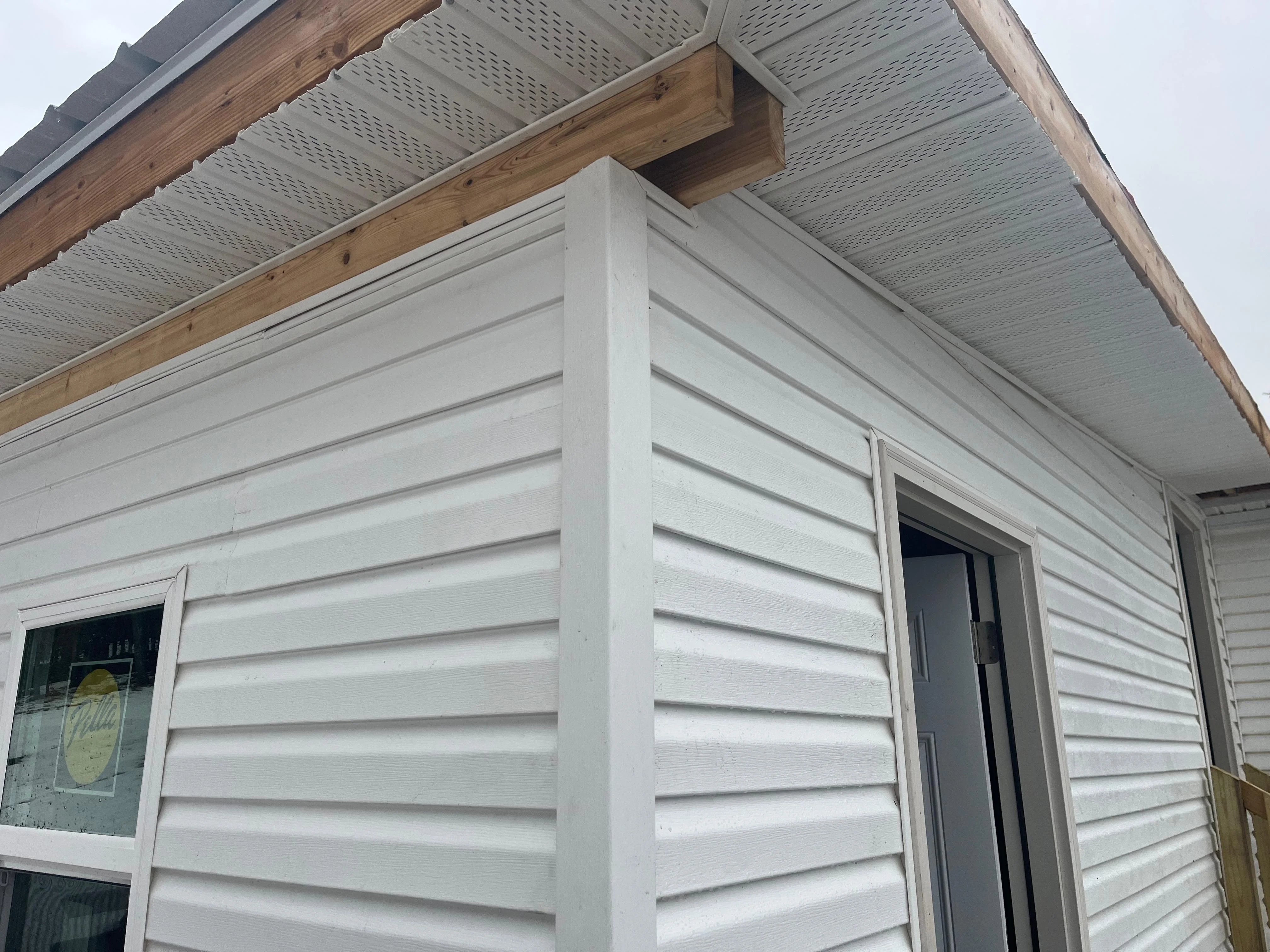 White horizontal lap siding with perforated soffit and wood beam eave, Vestal NY