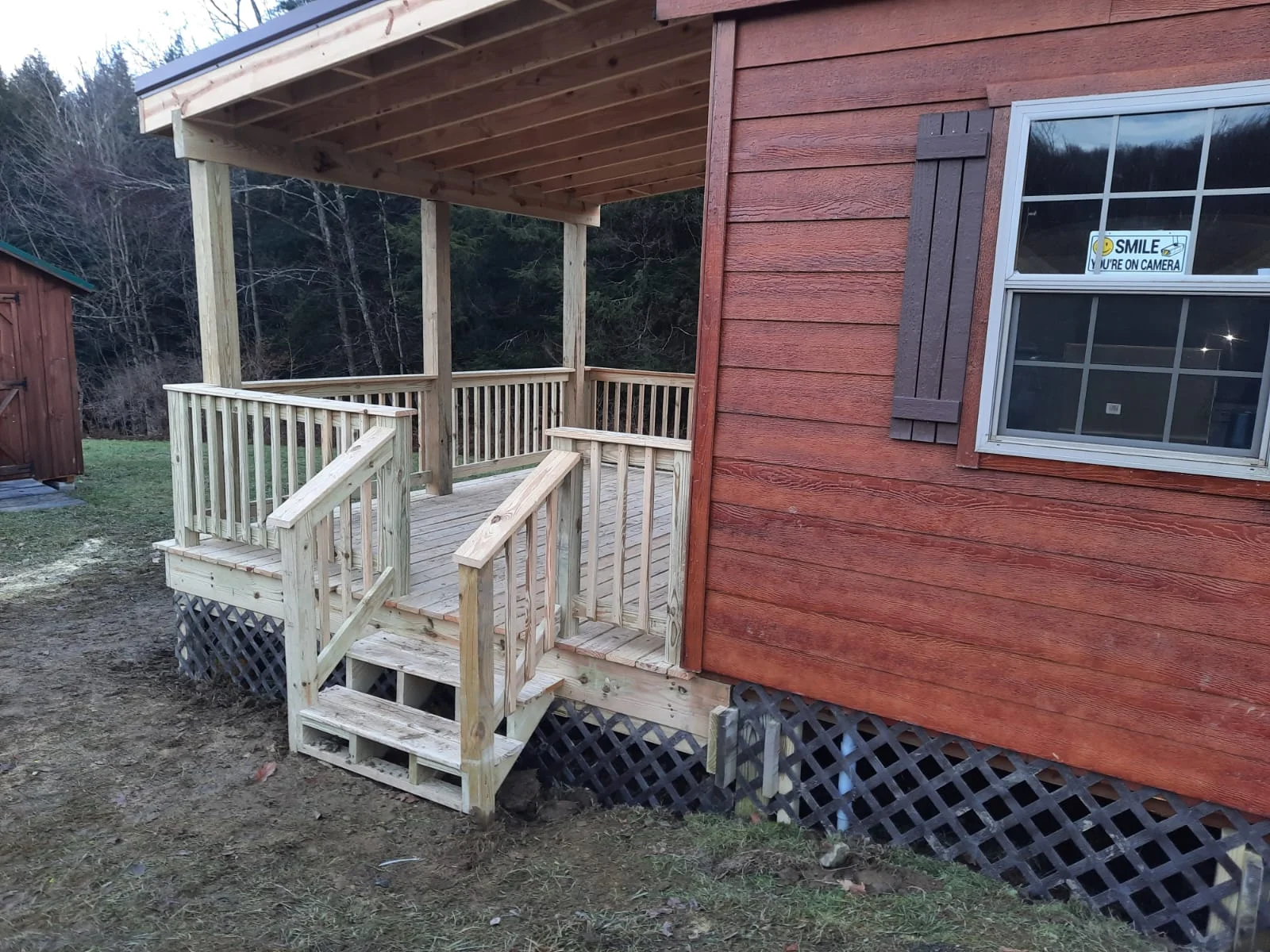 Screened porch with wood framing, white railings, large windows, and attached deck