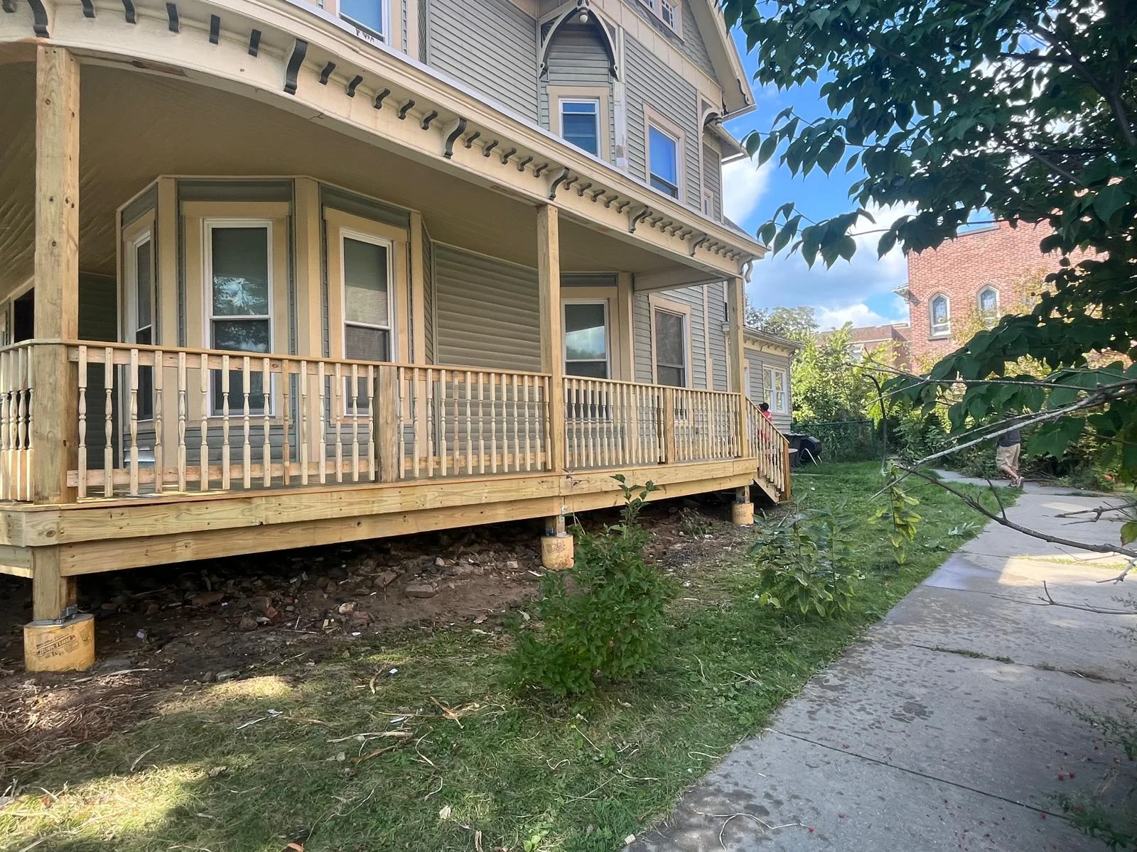 New wooden front porch with turned balusters and railings on Victorian house