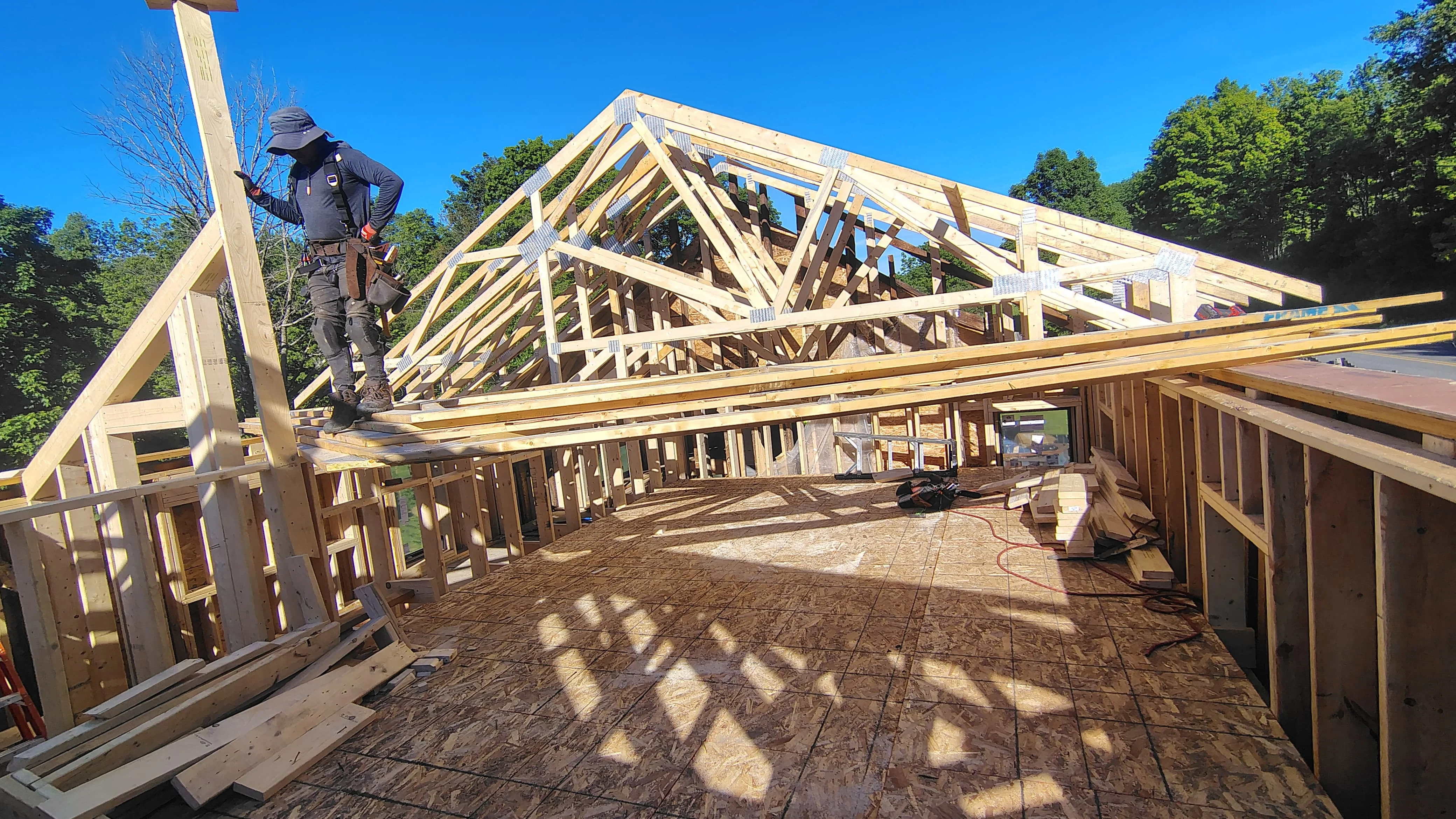 Residential wood framing with roof trusses, wall studs, and engineered structural members under construction