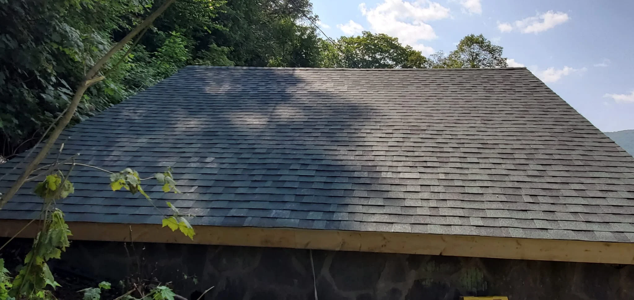 New charcoal gray asphalt shingle roof installation on residential structure