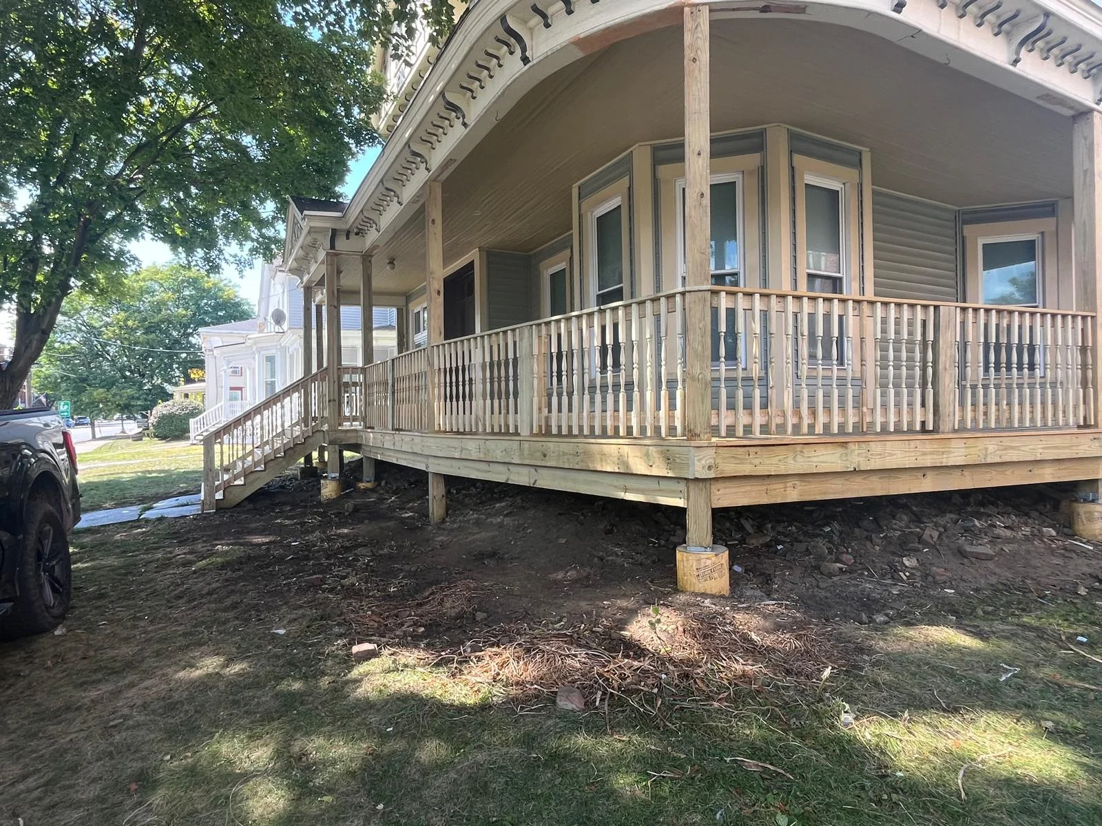 Wooden deck with railings and stairs attached to residential home exterior