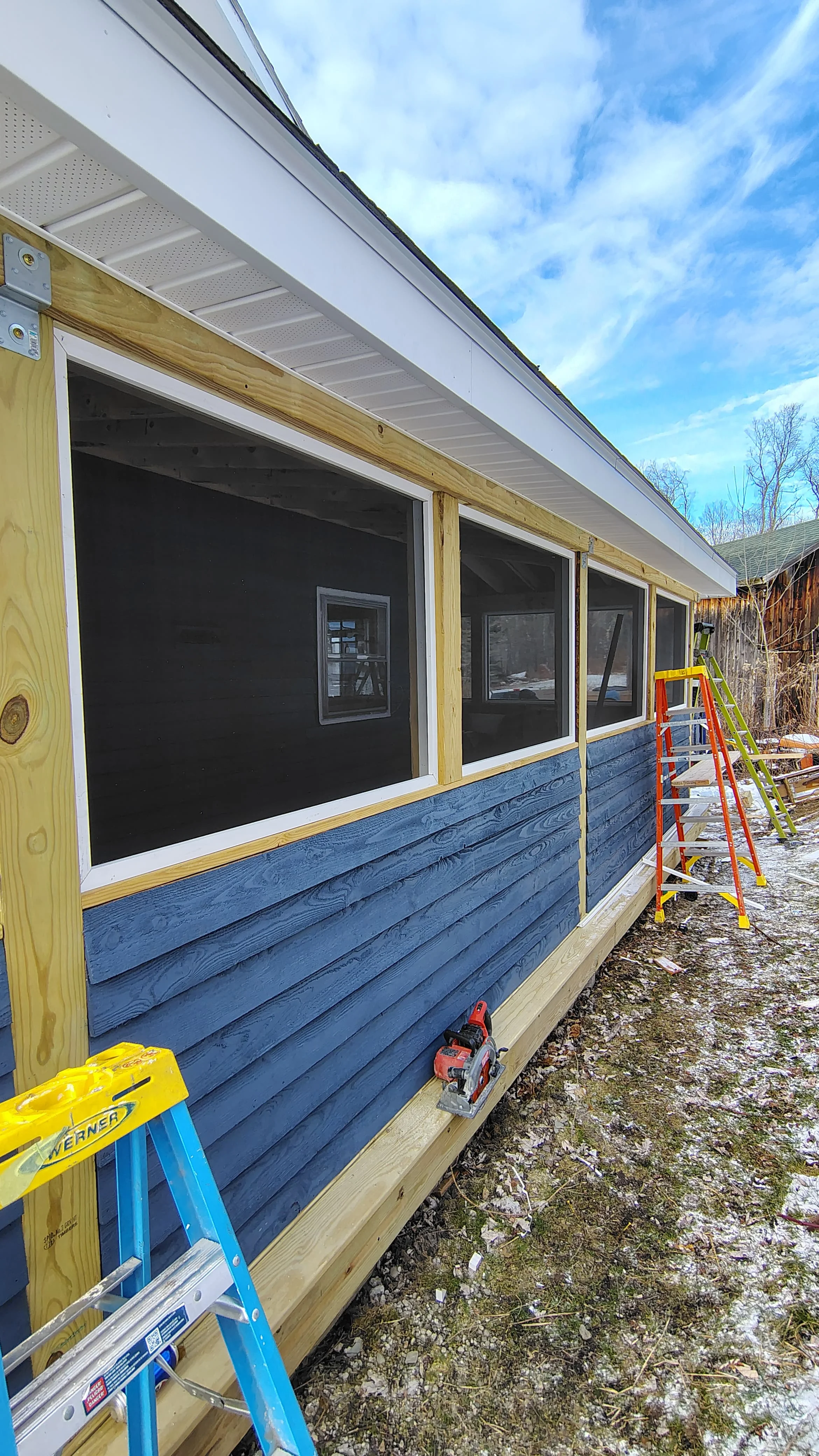 Blue lap siding, white soffit, and black-framed windows on commercial building, Vestal NY