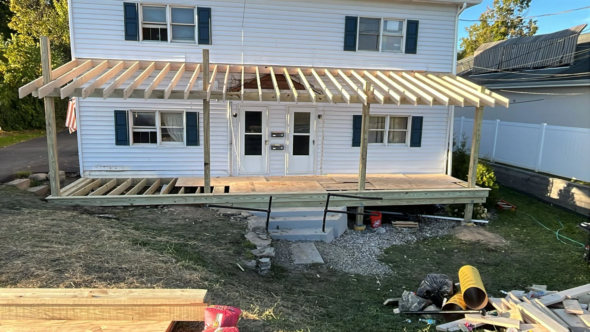 Pressure-treated wood deck and pergola framing under construction on residential home