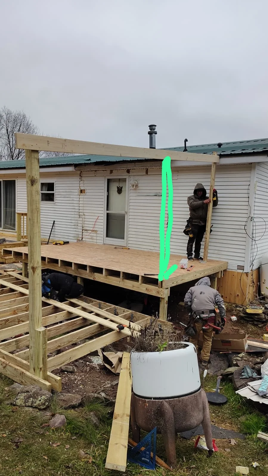 Pressure-treated wood deck with pergola frame under construction on mobile home