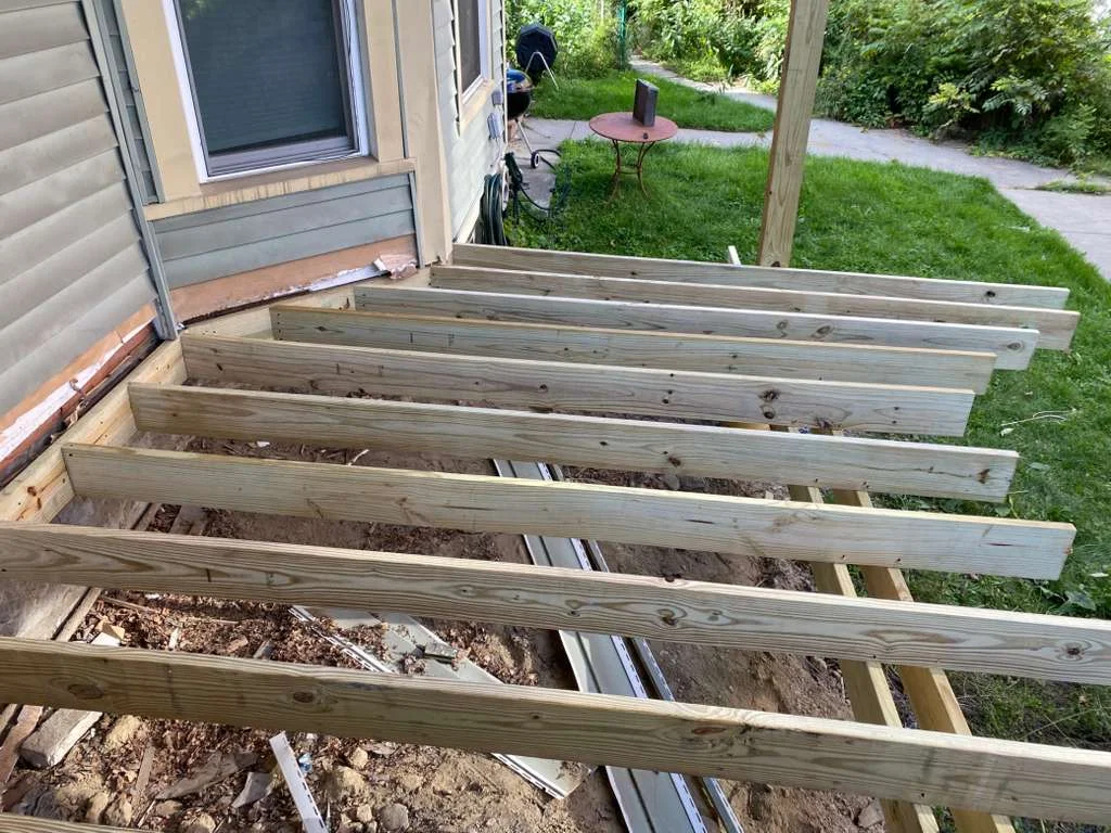 Pressure-treated deck joists framed and fastened during residential construction